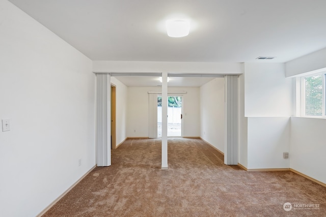 interior space featuring light colored carpet and multiple windows