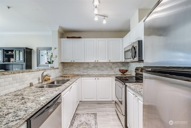 kitchen with white cabinets, appliances with stainless steel finishes, sink, and decorative backsplash