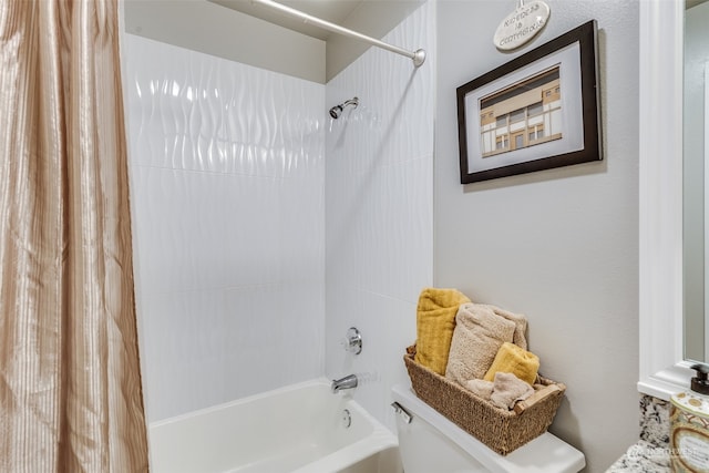 bathroom featuring shower / tub combo and toilet