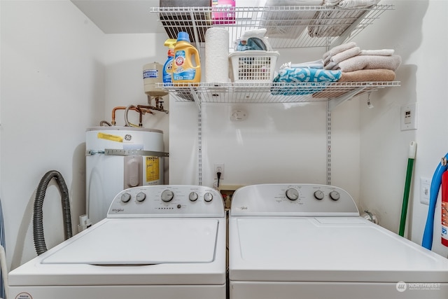 clothes washing area featuring secured water heater and independent washer and dryer