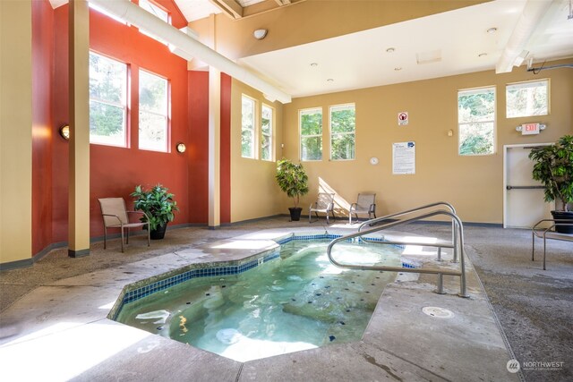 view of swimming pool with an indoor hot tub