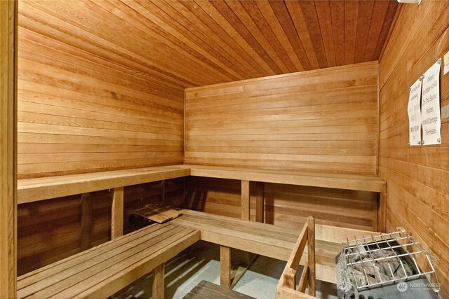 view of sauna with wooden ceiling and wooden walls