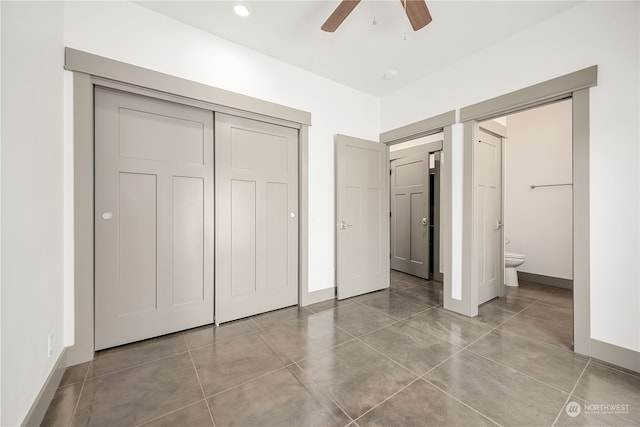 unfurnished bedroom featuring ceiling fan, ensuite bathroom, and a closet