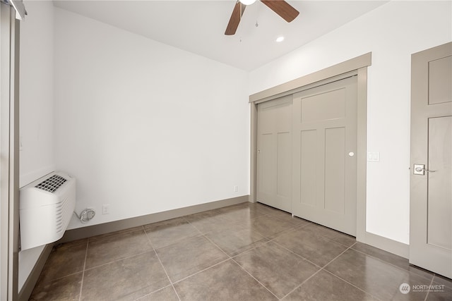 unfurnished bedroom with a closet, ceiling fan, and tile patterned floors