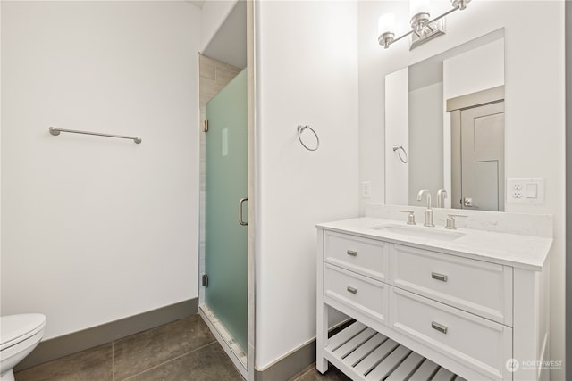 bathroom featuring vanity, toilet, a shower with door, and tile patterned floors