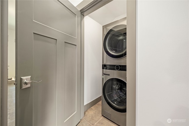 laundry area featuring stacked washer and clothes dryer and light tile patterned floors