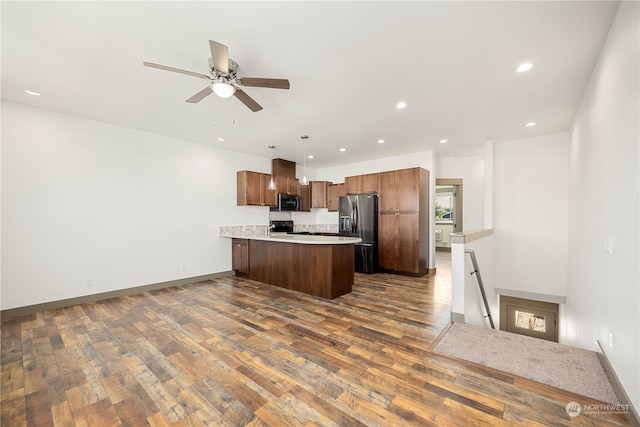 kitchen with ceiling fan, kitchen peninsula, decorative light fixtures, dark wood-type flooring, and appliances with stainless steel finishes