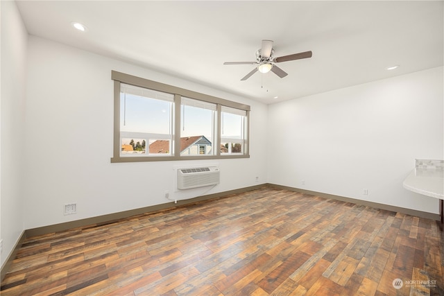 empty room featuring dark hardwood / wood-style floors, ceiling fan, and a wall mounted air conditioner