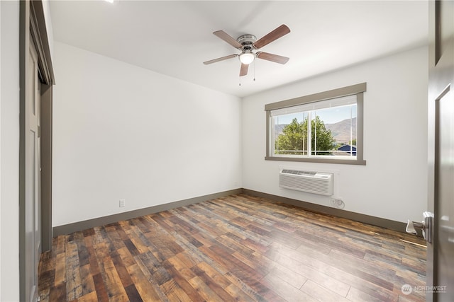 spare room featuring ceiling fan, dark wood-type flooring, and a wall mounted air conditioner