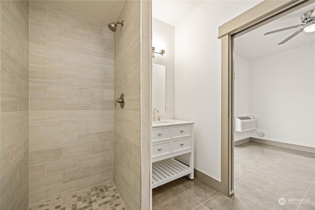 bathroom with vanity, a tile shower, tile patterned flooring, ceiling fan, and a wall mounted air conditioner