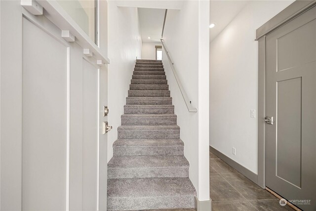 staircase featuring tile patterned flooring