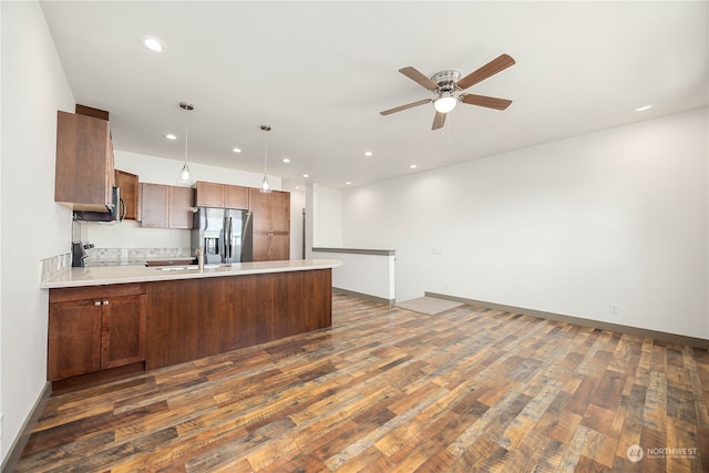 kitchen with kitchen peninsula, dark wood-type flooring, ceiling fan, and stainless steel appliances