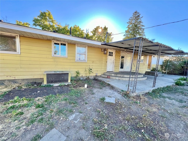 rear view of property featuring a patio and cooling unit