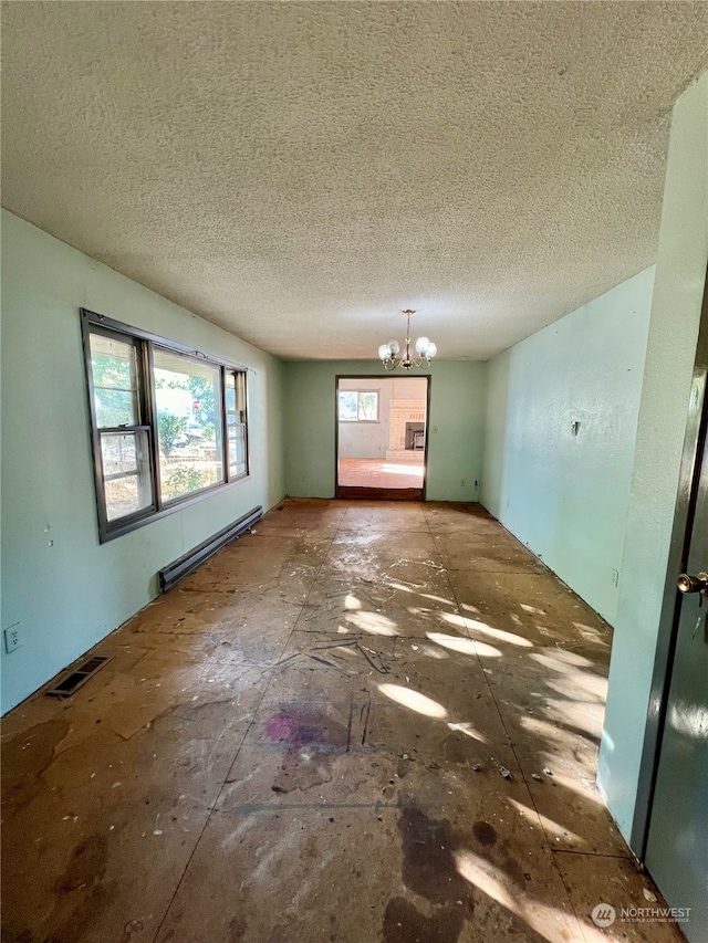 empty room with an inviting chandelier, a baseboard radiator, and a textured ceiling