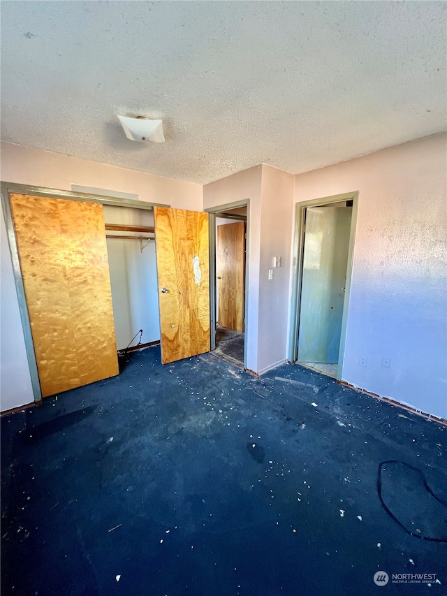 unfurnished bedroom with a textured ceiling and a closet