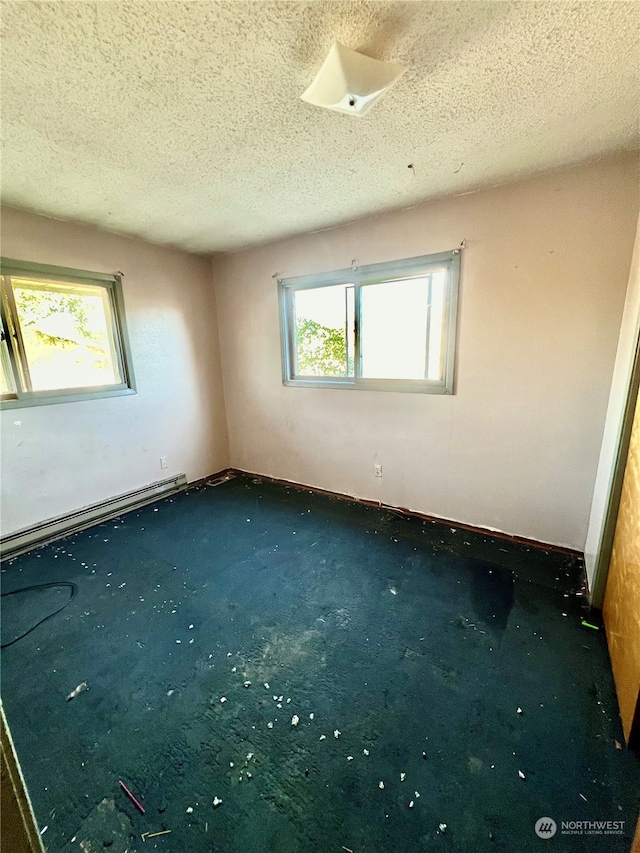 carpeted spare room featuring a textured ceiling and a baseboard radiator