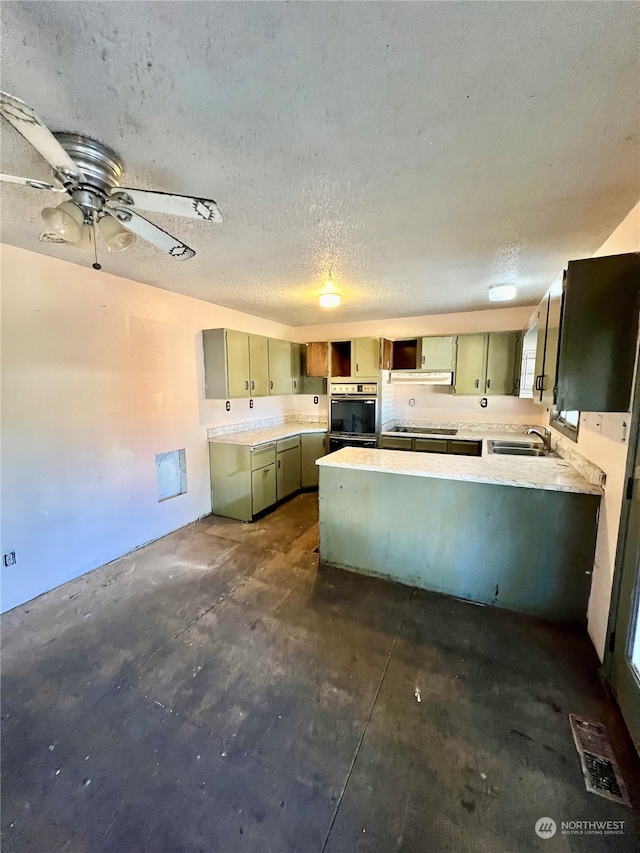 kitchen with ceiling fan, kitchen peninsula, sink, a textured ceiling, and black oven