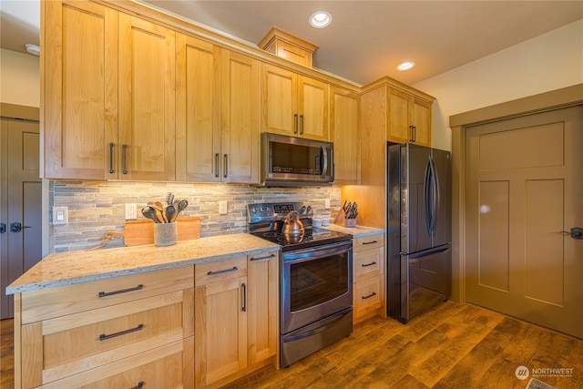 kitchen featuring stainless steel appliances, backsplash, light brown cabinets, dark hardwood / wood-style flooring, and light stone countertops