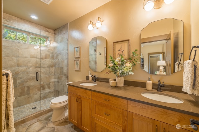 bathroom featuring vanity, toilet, and a shower with door