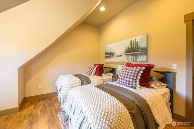 bedroom with lofted ceiling and light hardwood / wood-style floors