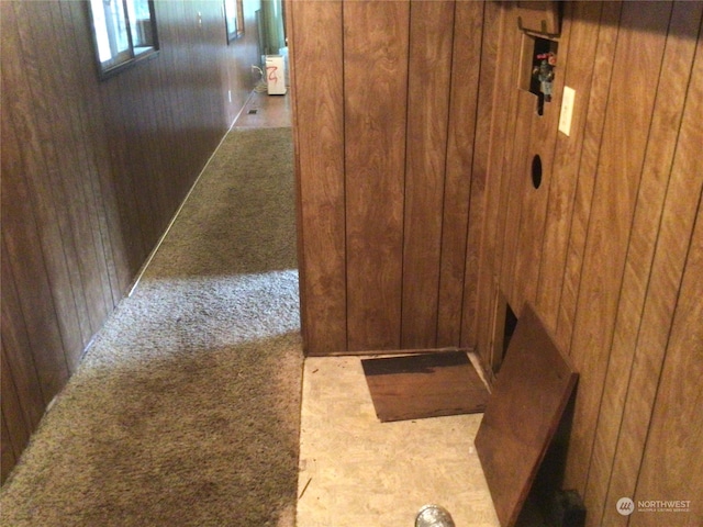 hallway with light carpet and wooden walls