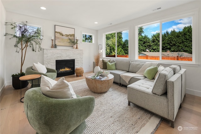 living room with light hardwood / wood-style floors and a fireplace