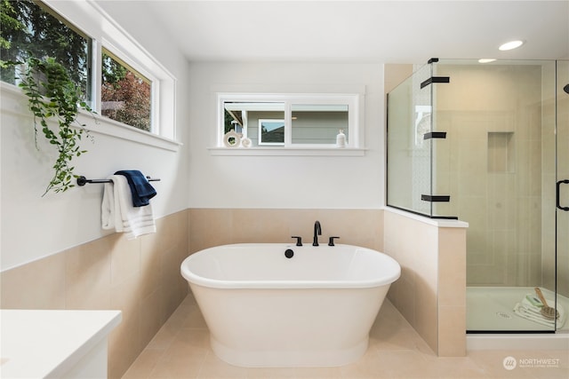 bathroom featuring tile walls, shower with separate bathtub, and tile patterned floors