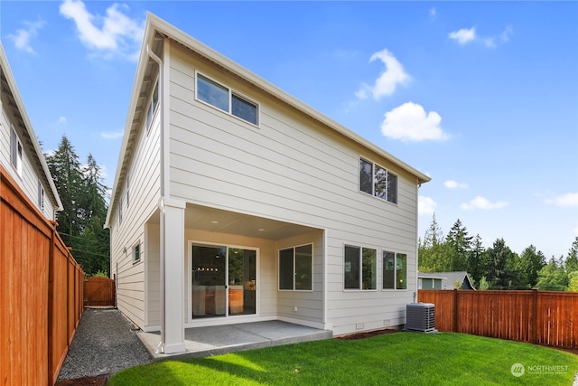 rear view of property with a patio, a yard, and central air condition unit