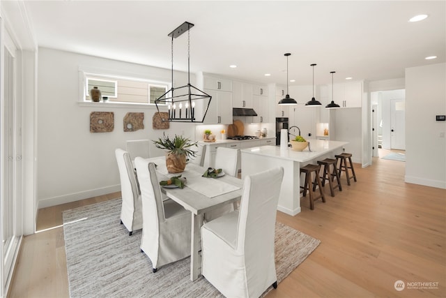 dining area featuring light hardwood / wood-style floors and an inviting chandelier