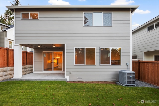 rear view of house featuring a lawn, a patio, and central air condition unit