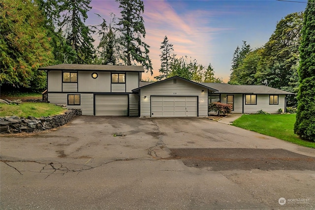 view of front of property with a garage and a lawn