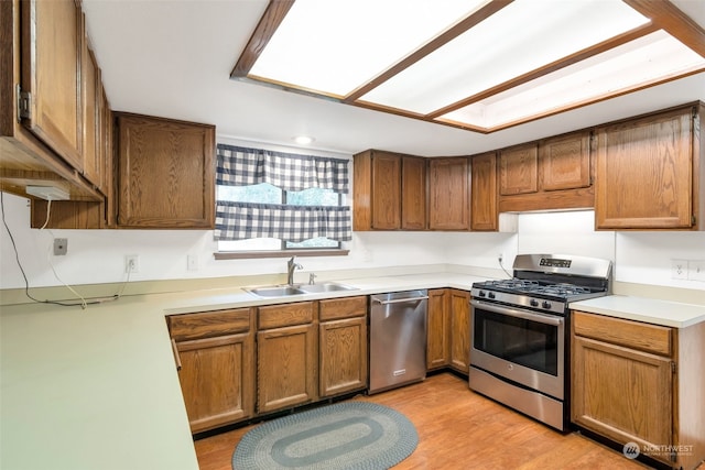 kitchen with light hardwood / wood-style floors, appliances with stainless steel finishes, and sink