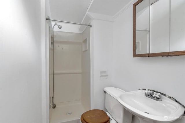 bathroom featuring a shower, sink, toilet, and crown molding