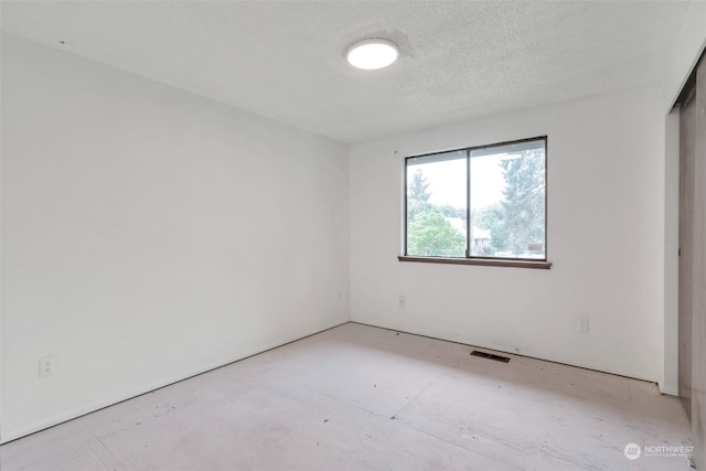 spare room with a textured ceiling