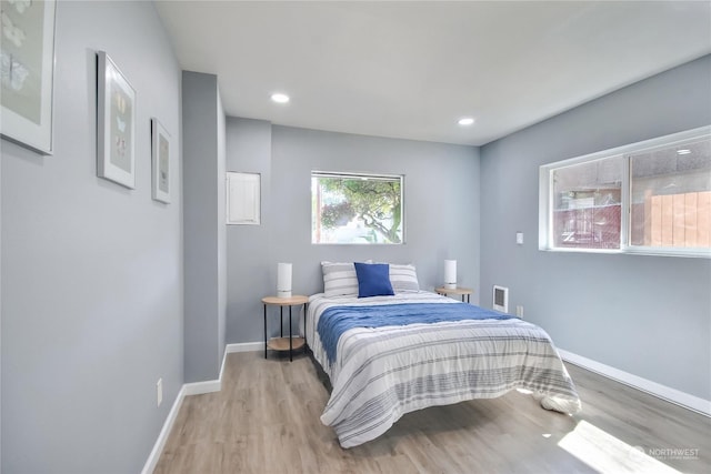 bedroom with recessed lighting, light wood finished floors, and baseboards