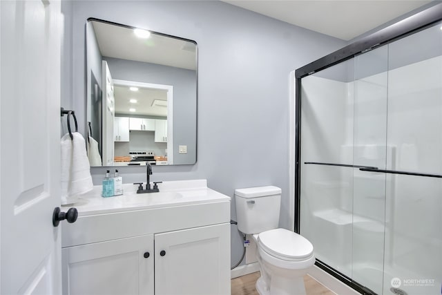 bathroom featuring vanity, hardwood / wood-style floors, toilet, and an enclosed shower