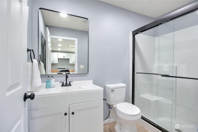 full bathroom with a shower stall, toilet, vanity, and wood finished floors