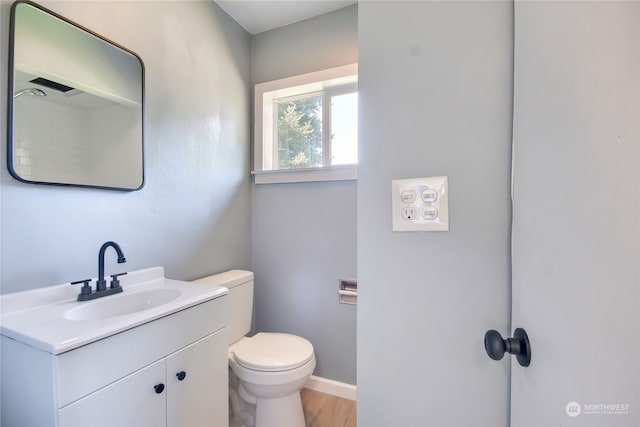 bathroom with wood-type flooring, vanity, and toilet