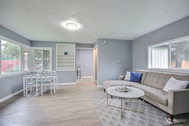 living room featuring a textured ceiling and light wood-type flooring