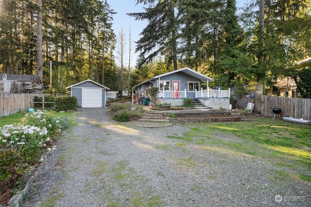 view of front of home with a garage, a wooden deck, and an outbuilding