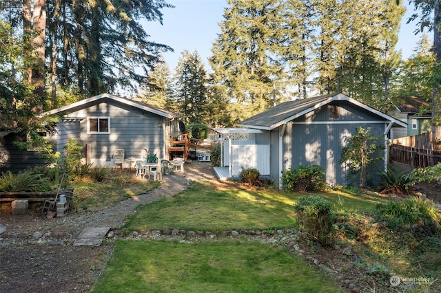 back of property featuring a lawn and an outdoor structure