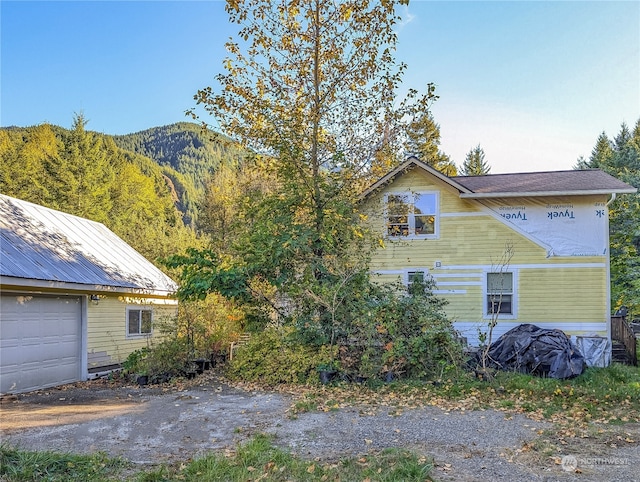 view of property exterior with a mountain view and a garage