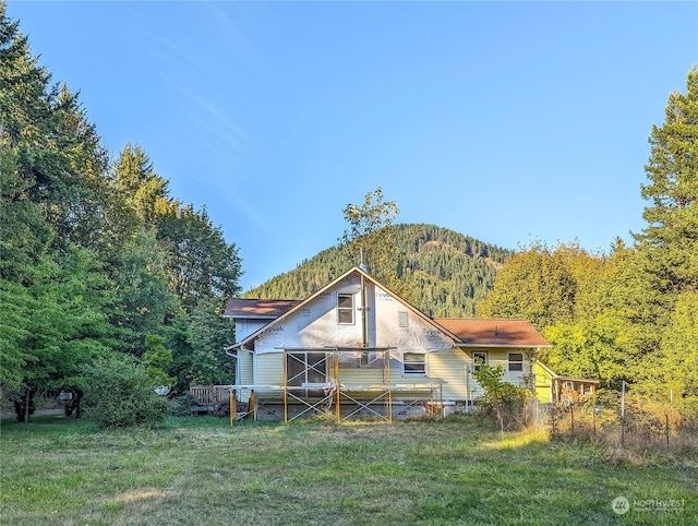 back of house featuring a mountain view and a yard