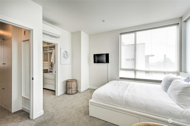 carpeted bedroom featuring a spacious closet, an AC wall unit, and a closet