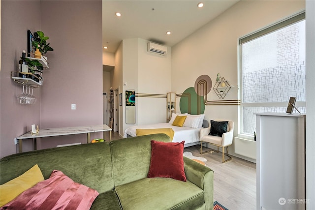 sitting room featuring light hardwood / wood-style flooring and an AC wall unit