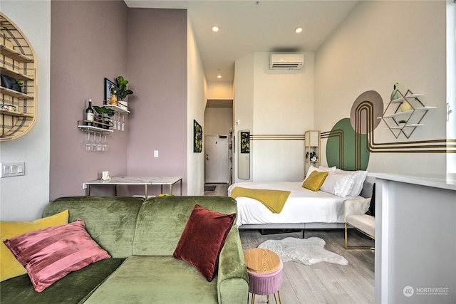 bedroom featuring hardwood / wood-style floors and a wall mounted air conditioner