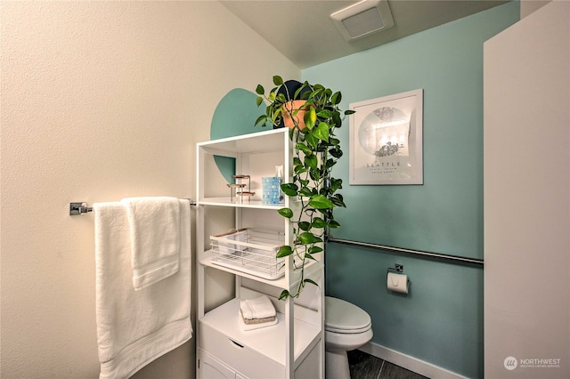 bathroom with hardwood / wood-style flooring and toilet