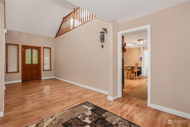 foyer entrance featuring light wood-style flooring, baseboards, and wallpapered walls