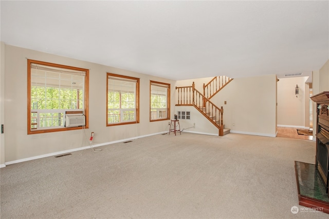 unfurnished living room with cooling unit and carpet floors