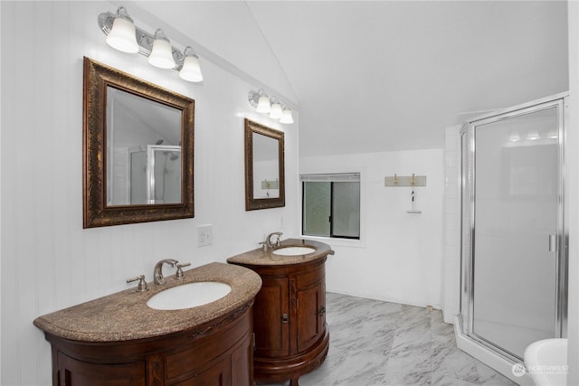 bathroom featuring two vanities, vaulted ceiling, a stall shower, marble finish floor, and a sink
